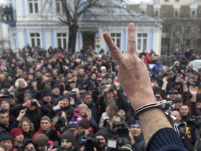 Former Georgian president Mikheil Saakashvili, back to a camera, gestures to protesters after he escaped with help from supporters and led them on a march toward parliament, where they planned to call for President Petro Poroshenko to resign in Kiev, Ukraine, Tuesday, Dec. 5, 2017. Hundreds of protesters chanting "Kiev, rise up!" blocked Ukrainian police as they tried to arrest former Georgian president Mikheil Saakashvili on Tuesday.