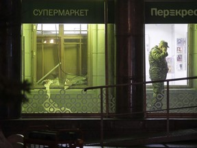 An investigator speaks on the phone inside a supermarket, after an explosion in St.Petersburg, Russia, Wednesday, Dec. 27, 2017. Russian officials say at least 10 people have been injured by an explosion at a supermarket in St. Petersburg.