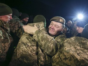 Ukrainian President Petro Poroshenko, centre, greets prisoners who were released by separatists in the town of Kramatorsk, eastern Ukraine, Wednesday, Dec. 27, 2017.