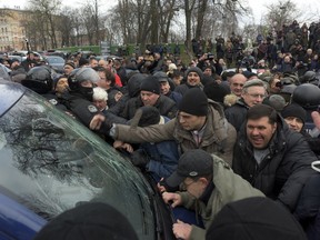 Supporters block a vehicle carrying former Georgian president Mikheil Saakashvili in Kiev, Ukraine, Tuesday, Dec. 5, 2017.  Some hundreds of protesters chanting "Kiev, rise up!" blocked Ukrainian police as they tried to arrest Saakashvili on Tuesday, who escaped and led supporters on a march toward parliament but was later detained.