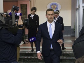 Russian opposition leader Alexei Navalny, center, leaves the Russia's Central Election commission in Moscow, Russia, Sunday, Dec. 24, 2017. The 41-year-old anti-corruption crusader has run a yearlong grass-roots campaign and staged waves of rallies to push the Kremlin to let him run.