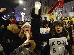 People protest during the "Chain of the lights" demonstration against judicial reforms, near the Presidential Palace in Warsaw, Poland, Thursday, Dec. 14, 2017.  Some thousands of protesters across Poland demonstrate against proposed new legislation that may give the ruling party control over courts and a key judicial body.