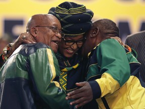 Winnie Madikizela-Mandela, centre, hugs front runner and Deputy President, Cyril Ramaphosa, right, and President Jacob Zuma, left, at the start of the ruling African National Congress (ANC) elective conference in Johannesburg, Saturday, Dec. 16 2017. The fight to replace South Africa's scandal-prone President Jacob Zuma began Saturday as thousands of delegates of the ruling African National Congress gathered to elect a new leader, with Zuma acknowledging "failures" that have threatened the party's future.