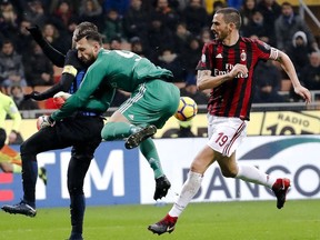 AC Milan goalkeeper Antonio Donnarumma, center, blocks Inter Milan's Mauro Icardi, left, as teammate Leonardo Bonucci, right, defends during an Italian Cup quarter-final soccer match between Milan and Inter Milan at the San Siro stadium in Milan, Italy, Wednesday, Dec. 27, 2017.