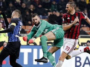 AC Milan goalkeeper Antonio Donnarumma, center, blocks Inter Milan's Mauro Icardi, left, as teammate Leonardo Bonucci, right, defends during an Italian Cup quarter-final soccer match between Milan and Inter Milan at the San Siro stadium in Milan, Italy, Wednesday, Dec. 27, 2017.