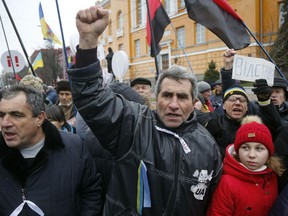 Supporters of the Movement of New Forces, the political party led by Mikheil Saakashvili, shout slogans calling for Ukraine's President Poroshenko to resign, in central Kiev, Ukraine, Sunday, Dec. 17, 2017. Writing on posters read: 'Impeachment'.