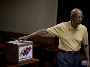 A man casts his ballot during Venezuelan mayoral elections in Caracas, Venezuela, Sunday, Dec. 10, 2017. Venezuelans will choose hundreds of mayors on Sunday in elections pitting candidates backed by President Nicolas Maduro against a fractured opposition still bruised by a poor showing in recent gubernatorial voting.