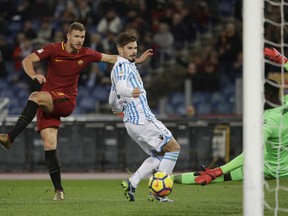 Roma's Edin Dzeko, left, scores his side's first goal during an Italian Serie A soccer match between AS Roma and Spal, at the Olympic stadium in Rome, Friday, Dec. 1st, 2017. (AP Photo/Gregorio Borgia)
