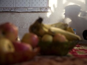 North Korean woman S.Y. casts a shadow near fruits laid out for a prayer meeting at her home near the city of Chaoyang in northeastern China's Liaoning province. S.Y. is among thousands, or perhaps tens of thousands, of North Korean women who have been sold as brides in China, mostly to poor farmers.