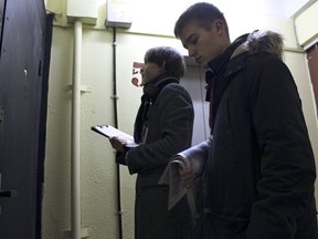 Young opposition activists Alexander Pelevin, 17, left, and Kirill Strizhov, 15, ring a door bell at a residential building in Moscow, Russia, aiming to deliver opposition newspapers and leaflets on Saturday, Dec. 9, 2017. While most of their classmates relax at home, Russian teenagers Kirill Strizhov and Alexander Pelevin dedicate their weekends canvassing for opposition leader Alexei Navalny, the lawyer turned anti-corruption campaigner who is running for president in next year's elections.