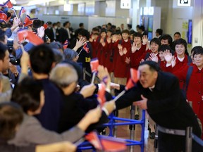 North Korean women's national soccer team members are welcomed with their national flags waved upon arrival at Haneda international airport in Tokyo Tuesday, Dec. 5, 2017. North Korean women's and men's national soccer teams arrived in Tokyo as exception to Japan's entry ban as part of ongoing sanctions against Pyongyang's missile and nuclear development. North Korea is competing against Japan, China and South Korea in the upcoming E-1 Football Championship held in Japan.