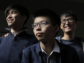 From left, Hong Kong's young democracy leaders Lester Shum, Joshua Wong and Alex Chow pose for photographers in front of the High Court in Hong Kong, Thursday, Dec. 7, 2017. Wong faces a possible new prison sentence in a case stemming from 2014 protests in the semiautonomous Chinese city. He's among a group of activists awaiting sentencing following their convictions months earlier.