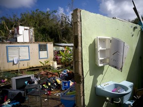 FILE - In this Oct. 14, 2017 file photo, what was once the home Arden Dragoni and his family lies in ruins after the passing of Hurricane Maria in Toa Baja, Puerto Rico. The Dragoni family lost everything on Sept. 20: clothes, household goods, and an old car, as well as the family's source of income: Arden Dragoni's construction work.
