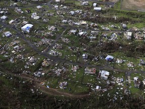 FILE - In this Sept. 28, 2017 file photo, homes and other buildings destroyed by Hurricane Maria lie in ruins in Toa Alta, Puerto Rico. Puerto Rico's governor on Monday, Dec. 18, 2017 ordered authorities to review all deaths reported since Hurricane Maria hit nearly three months ago amid accusations that the U.S. territory has vastly undercounted storm-related deaths.