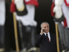 In this Tuesday, Dec. 5, 2017 photo, Brazil's President Michel Temer talks on his cell phone outside the Planalto Presidential Palace, in Brasilia, Brazil. Temer urged business leaders on Friday, Dec. 8, 2017, to support an unpopular social security overhaul in a push to get it passed. The pension reform is a central pillar of Temer's plan to help Brazil recover from a protracted recession. But he hasn't corralled enough votes to pass the measure, and the window is closing as next year's elections approach.