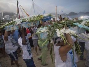 People carry small-scaled boats filled with flowers into the waters of Copacabana beach as an offering for Yemanja, goddess of the sea on Copacabana beach in Rio de Janeiro, Brazil, Friday, Dec. 29, 2017. As the year winds down, Brazilian worshippers of Yemanja celebrate the deity, offering flowers and launching large and small boats into the ocean in exchange for blessings in the coming year. The belief in the goddess comes from the African Yoruban religion brought to America by West African slaves.