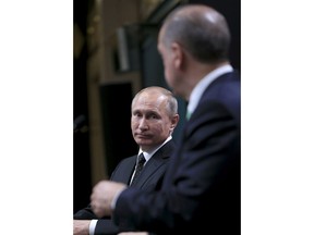 Russia's President Vladimir Putin, left, listens to Turkey's President Recep Tayyip Erdogan, right, during a joint news statement following their meeting at the Presidential Palace in Ankara, Monday, Dec. 11, 2017. The two men met Monday evening to discuss developments in Syria and the Middle East, as well as bilateral relations, according to the Turkish President's office. (Pool Photo via AP)