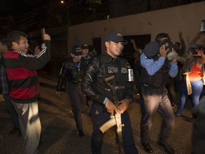 Residents cheer and shout anti-government slogans as national police arrive at their headquarters to join a police strike in Tegucigalpa, Honduras, Monday, Dec. 4, 2017. Some police are striking to protest 16 days straight of working the streets amid a slow presidential election vote count that triggered protests and a curfew, as well as to demand higher salaries.