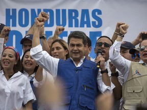 Honduran President Juan Orlando Hernandez raises his right fist as he speaks to supporters, in Tegucigalpa, Honduras, Thursday, Dec. 7, 2017. Eight Latin American governments on Wednesday applauded Honduras' willingness to recount disputed votes in the presidential elections, but questions remain about how thorough that recount will be.