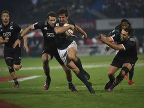South Africa's Kwagga Smith, front, slips through New Zealand's defence in the final of the World Rugby Sevens Series in Dubai, the United Arab Emirates, Saturday, Dec. 2, 2017. South Africa beat New Zealand 24-12, defending its last year's title.
