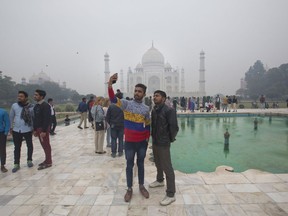 In this Dec. 6, 2017, photo, Indian and foreign tourists take selfies in front of the Taj Mahal in Agra, India. A lawmaker from India's ruling party called the Taj Mahal a blot on Indian culture, saying in October that the famous tourist site had been built by Muslim traitors. A series of incidents this fall have reinforced fears that anti-Muslim sentiment has hardened in India in the three years since a right-wing Hindu nationalist party led by Prime Minister Narendra Modi swept to power.