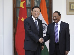 Indian National Security Adviser Ajit Doval, right, poses with Chinese State Councillor Yang Jiechi for a photo before their meeting in New Delhi, India, Friday, Dec. 22, 2017. Special representatives of India and China hold the 20th round of negotiations on the border issues on Friday. The meeting, which comes four months after the forces of the two sides confronted each other at the Doklam plateau.