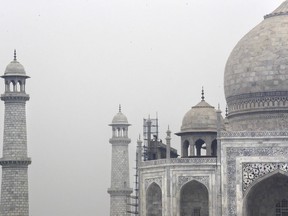 In this Tuesday, Dec. 5, 2017, photo, Indian workers clean the discoloration of the Taj Mahal caused by environmental pollution in Agra, India. Authorities in India are trying to figure out how workers will scale the Taj Mahal's majestic but delicate dome as they complete the first thorough cleaning of the World Heritage site since it was built 369 years ago. Work on the mausoleum's minarets and walls is almost finished, after workers began the makeover in mid-2015. They've been using a natural mud paste to remove yellow discoloration and return the marble to its original brilliant white. Called fuller's earth, it's the same clay that some people smother on their skin as a beauty treatment.