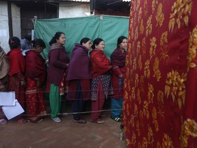 Nepalese women stand and wait on a queue to cast their vote during the legislative elections in Thimi, Bhaktapur, Nepal, Thursday, Dec. 7, 2017. Millions of people in Nepal are voting in the final phase of elections for members of the national and provincial assemblies. About 12 million voters in the southern half of the Himalayan nation are voting Thursday.