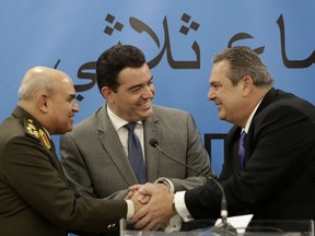 Cyprus' Defense Minister Christoforos Fokaides, center, shakes hands with his Greek counterpart Panos Kammenos, right, and Egyptian Defense Minister Sedki Sobhi after their first of three-way talks at the "Zenon" Search and Rescue Coordination Center next to Cyprus' Larnaca international airport, on Thursday, Dec. 14, 2017. The defense ministers of Cyprus, Egypt and Greece have agreed to step up cooperation in combatting drug, weapons and people trafficking in the east Mediterranean and to share information on countering the threat of terrorism.