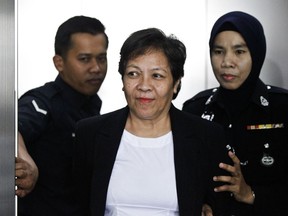 Australian Maria Elvira Pinto Exposto, center,  is escorted by a police officer during a court hearing at Shah Alam High Court in Shah Alam, Malaysia, Wednesday, Dec. 27, 2017. Exposto was arrested on Dec. 7, 2014 at Kuala Lumpur airport with 1.5 kilograms (3.3 pounds) of methamphetamine stitched into the compartment of a backpack she was carrying.