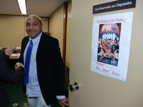 In this May 28, 2013 photo released by the government news agency Agencia Brasil, professional clown and lawmaker Francisco Everardo Oliveira Silva shakes a person's hand at Congress in Brasilia, Brazil. The clown universally known as Tiririca, elected twice to Brazil's Congress under the slogan "It can't get any worse," apparently feels that it did. He says he is too embarrassed by his fellow lawmakers to run again.