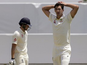 Australia's Mitchell Starc, right, puts his hands on his head after having an appeal dismissed for the wicket of England's Dawid Malan, left, during the second day of their Ashes cricket test match in Perth, Australia, Friday, Dec. 15, 2017.