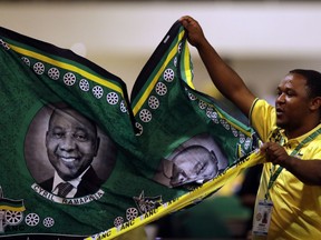 A delegate holds party paraphernalia with the face of the African National Congress (ANC) President, Cyril Ramaphosa, during the closing of the ANC's elective conference in Johannesburg, Wednesday Dec. 20, 2017. Ramaphosa, once Nelson Mandela's preferred successor, is proclaiming a "victory over the doomsayers" after some observers said the party could split amid growing frustration over scandal-prone President Jacob Zuma.