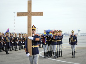 Honor guard soldiers carry the coffin of the late Romanian King Michael I at Bucharest's Henri Coanda airport, outside Bucharest, Romania, Wednesday, Dec. 13, 2017. Former King Michael, who ruled Romania twice and was forced to abdicate by the communists in 1947, died on Dec. 5 in Switzerland at age 96.