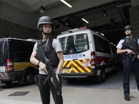 Police officers stand guard next to prison bus which carries British banker Rurik Jutting upon his arrival at the High Court in Hong Kong, Tuesday, Dec. 12, 2017. British banker, Cambridge University-educated Rurik Jutting serving a life sentence in Hong Kong for murdering two Indonesian women, including one he spent days torturing while on cocaine, is seeking to appeal his conviction at the Court of Appeal.