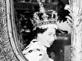 Queen Elizabeth II is seen through the window of the royal carriage, 02 June 1953 after being crowned solemnly at Westminter Abbey in London.