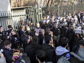In this Dec. 30, 2017 file photo, anti-riot Iranian police prevent university students to join other protesters over Iran's weak economy, in Tehran, Iran.