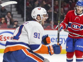 New York Islanders John Tavares celebrates his game winning goal during overtime against the Montreal Canadiens in Montreal Monday as Habs Jonathan Drouin watches.