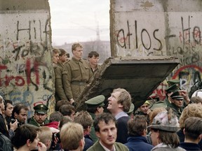 Picture taken on November 11, 1989 shows West Berliners crowd in front of the Berlin Wall as they watch East German border guards demolishing a section of the wall in order to open a new crossing point between East and West Berlin