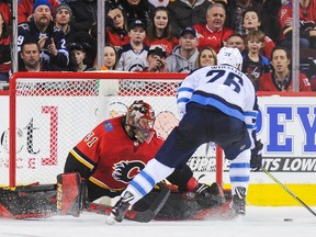 Blake Wheeler of the Winnipeg Jets scores the game-winning goal against Mike Smith  of the Flames during a shootout in their game Saturday at Scotiabank Saddledome in Calgary.