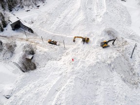 Excavators remove the snow on the site of an avalanche that covered the railway of the Brig Visp Zermatt Bahn company between Visp and Taesch on January 10, 2018 near Sankt Niklaus, Swiss Alps.