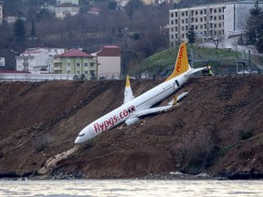 A Pegasus Airlines Boeing 737 passenger plane is seen struck in mud on an embankment, a day after skidding off the airstrip, after landing at Trabzon's airport on the Black Sea coast on January 14, 2018.