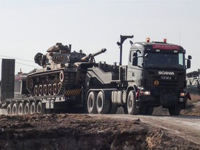 A photo made available by the Dogan New Agency shows Turkish army military trucks transporting armoured vehicles to reinforce the border units in Sanliurfa close to the Syrian border on January 16, 2018.