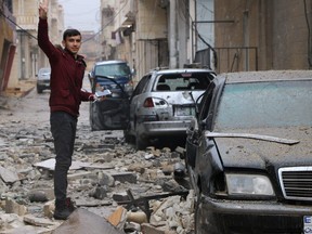 A man gestures while standing amidst debris in the Syrian Kurdish town of Jandairis in the northern Afrin district, on January 24, 2018.