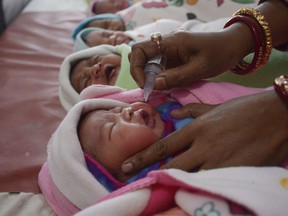 An Indian health official administers polio vaccine drops to new born babies at a government hospital in Agartala on January 28, 2018.