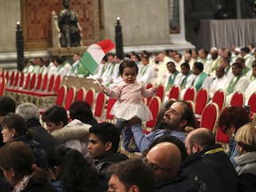 Gandi Almubayed, a Syrian refugee, holds his ten-month daughter Stella, prior to a Mass on the occasion of the world day for migrants and refugees, at the Vatican, Sunday, Jan. 14, 2018.