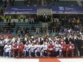 FILE - In this April 6, 2017, file photo, women's ice hockey players of South Korea, in white, and North Korea, in red, pose for a photo with International Ice Hockey Federation officials after their Ice Hockey Women's World Championship Division II Group A game in Gangneung, South Korea. The 22 North Korean athletes now invited to compete at the Olympics in February 2018 are not likely to bring home any medals across the border from South Korea. The 23 players on South Korea's roster will now have 12 North Koreans added three weeks before their opening game against Switzerland.
