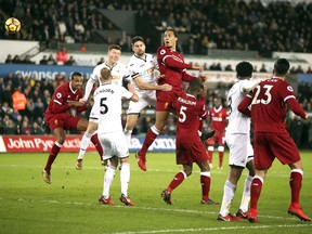 Liverpool's Virgil van Dijk, centre, heads the ball towards goal, during the English Premier League soccer match between Swansea City and Liverpool, at the Liberty Stadium, in Swansea, Wales, Monday, Jan. 22, 2018.