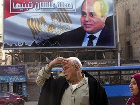 A billboard supporting Egyptian President Abdel-Fattah el-Sissi in the presidential election scheduled for March hangs in downtown Cairo, Egypt, Monday, Jan. 22, 2018.  El-Sissi is virtually guaranteed to win a second four-year term amid a heavy clampdown on dissent. Arabic reads, "So you can build it."