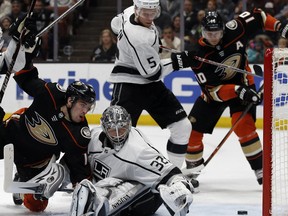 A shot by Anaheim Ducks center Adam Henrique, left, gets behind Los Angeles Kings goaltender Jonathan Quick (32) as defenseman Christian Folin (5), of Sweden, defends against right wing Corey Perry (10) during the second period of an NHL hockey game in Anaheim, Calif., Friday, Jan. 19, 2018. The puck stayed out of the goal.